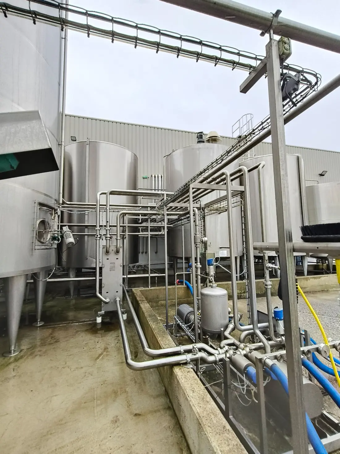 Site agroalimentaire avec cuves inox et convoyeur aérien
